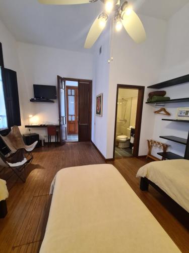 a bedroom with a bed and a room with a desk at Posada El Capullo in Colonia del Sacramento