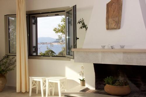 a living room with a fireplace and a window at Mani Apartments in Agios Nikolaos