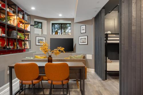 a dining room with a table and orange chairs at Wrigleyville Suites in Chicago