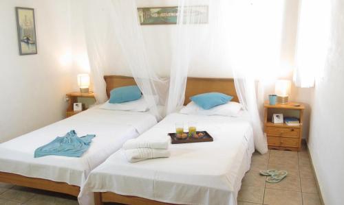 two beds in a hotel room with a tray of food at Mani Apartments in Agios Nikolaos