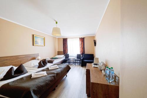 a hotel room with two beds and a table at Stratos in Łeba