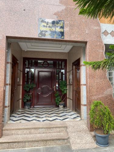 an entrance to a building with a brown door at Huge 4 bedroom Condo 2 min walking to TGV train in Kenitra