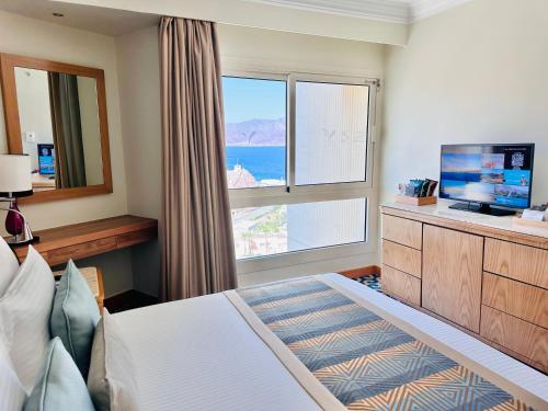 a bedroom with a bed and a large window at Steigenberger Hotel & Nelson Village, Taba in Taba
