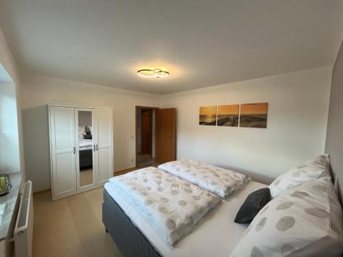 a small bedroom with a bed and a cabinet at Ferienwohnung Eifel-Ring in Siebenbach