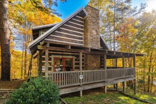 a log cabin with a porch in the woods at Rockin R Lodge by Eden Crest in Sevierville