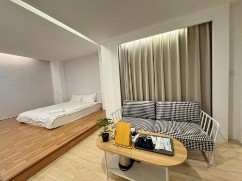 Habitación con cama, sofá y mesa. en 日日藍旅市區民宿, en Hualien City