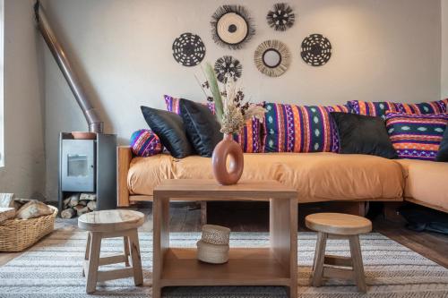 a living room with a couch and a table with stools at Hacienda El Porvenir by Tierra del Volcan in Machachi