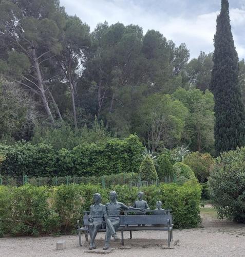 a statue of four people sitting on a bench at Masia Bernat in Tortosa