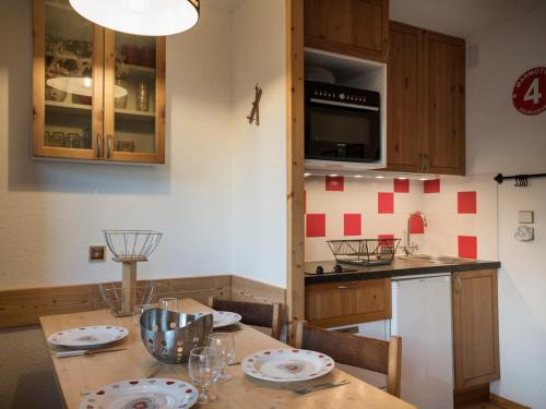 une cuisine avec une table en bois et des plaques de cuisson. dans l'établissement Charmant 2 pièces rénové à Courchevel avec balcon et Wifi - FR-1-575-27, à Courchevel