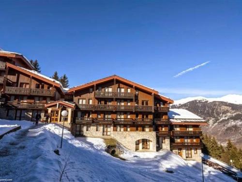 un lodge de ski dans les montagnes avec de la neige au sol dans l'établissement Charmant 2 pièces rénové à Courchevel avec balcon et Wifi - FR-1-575-27, à Courchevel