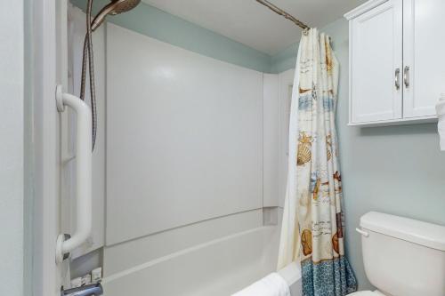 a bathroom with a shower curtain and a toilet at Summer Winds Condo Unit 216 in Indian Beach