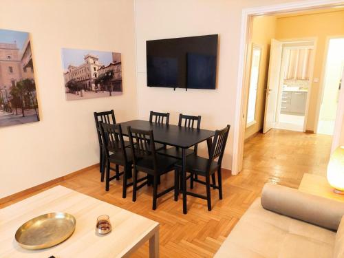 雅典Comfortable apartment in Syntagma square的配有黑色桌子和椅子的餐厅