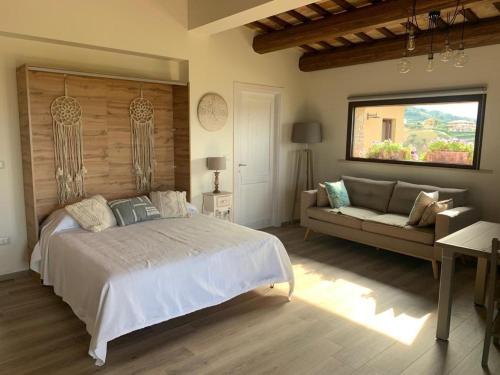 a bedroom with a large bed and a couch at La Chiocciola Resort in Mutignano