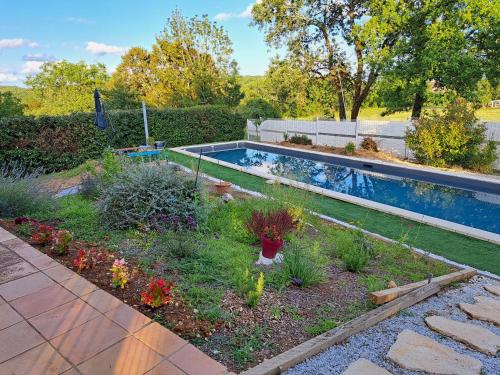 un jardin avec une piscine et quelques plantes dans l'établissement Le Lot pour tous les repos, à Crayssac