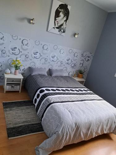 une chambre avec un lit avec une couette noire et blanche dans l'établissement Le Lot pour tous les repos, à Crayssac