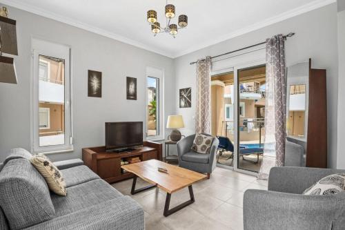 a living room with a couch and a tv at Villa Blue Dreams in Maleme in Ayiá