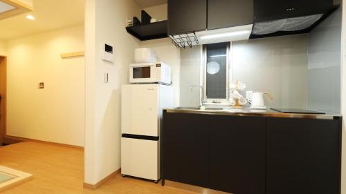 a kitchen with a white refrigerator and a microwave at Japanese Bath House 5min to Namba Free Parking101 in Osaka