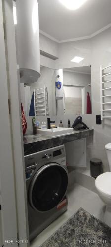 a kitchen with a sink and a washing machine at Квартира- студия in Chişinău