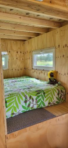 a bed in the inside of a tiny house at The Poolhouse in Buitenpost
