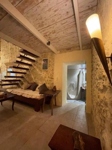 a living room with a couch and a staircase at Village Little House at Roustika in Roústika