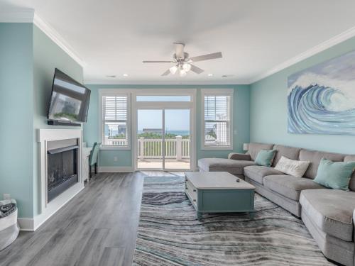 een woonkamer met een bank en een tv bij Strand Bungalow in Surf City