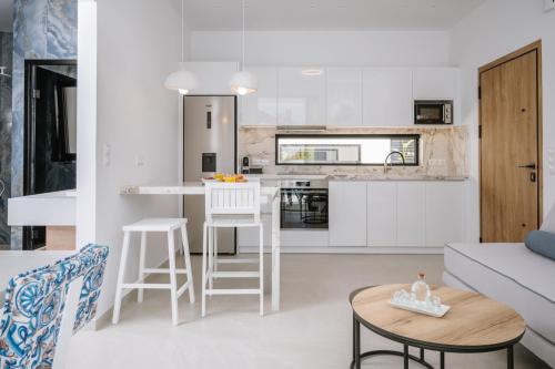 a kitchen and living room with white cabinets at Sardines Luxury Suites in Hersonissos