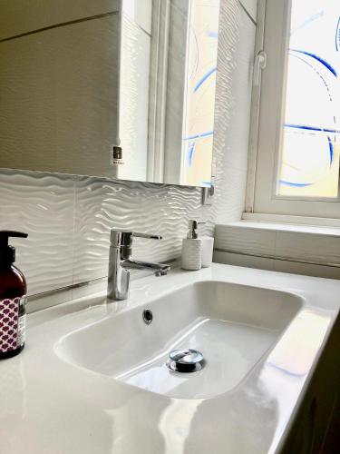 a white sink in a bathroom with a window at Casa Varela en Noia in Noya