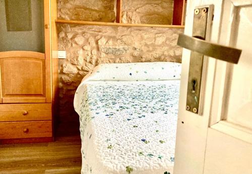 a small bed in a room with a wooden door at Casa Varela en Noia in Noya