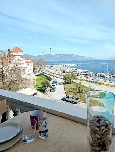 a table with a view of the ocean from a balcony at Gavalas Apartment in Agios Konstantinos in Agios Konstantinos Fthiotida