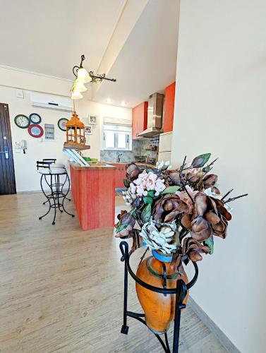 a vase of flowers on a stand in a kitchen at Gavalas Apartment in Agios Konstantinos in Agios Konstantinos Fthiotida