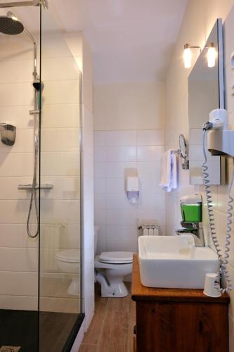 a bathroom with a sink and a toilet and a shower at The Originals City, Hôtel Armen Le Triton, Roscoff in Roscoff