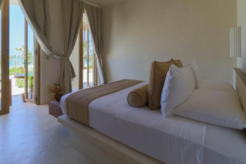 a bedroom with a bed with a couch and a window at Suites Panamera in Tulum