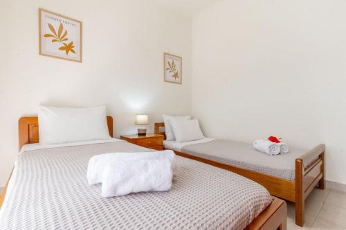 two twin beds in a room with white walls at Mike's House in Kremasti near the Beach Rhodes in Kremasti