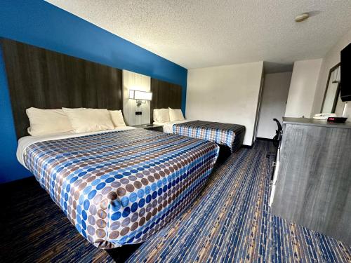 a hotel room with two beds and blue walls at Red Carpet Inn Orchard Park in Orchard Park
