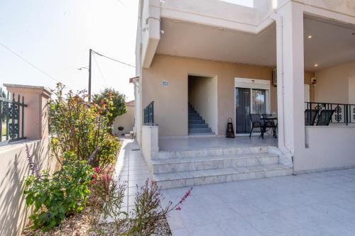a house with stairs and a porch with a patio at Mike's House in Kremasti near the Beach Rhodes in Kremasti