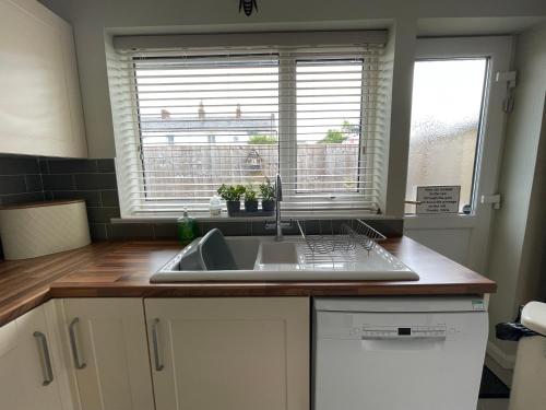 eine Küche mit Spüle und Fenster in der Unterkunft Park View Cottage - 3 Beds - 2 Bedrooms in Sewerby in Sewerby