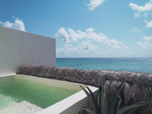 a swimming pool with the ocean in the background at Suites Panamera in Tulum