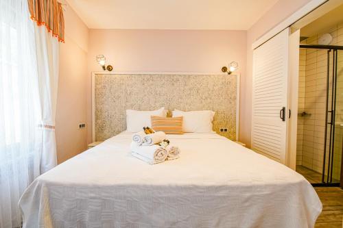 a bedroom with a large white bed with towels on it at Nirvana Hotel in Bozcaada