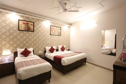 a hotel room with two beds and a mirror at Hotel Grand Kiara Delhi Airport By SS Group in New Delhi