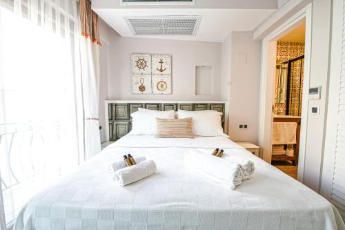 a bedroom with a white bed with two pillows on it at Nirvana Hotel in Bozcaada