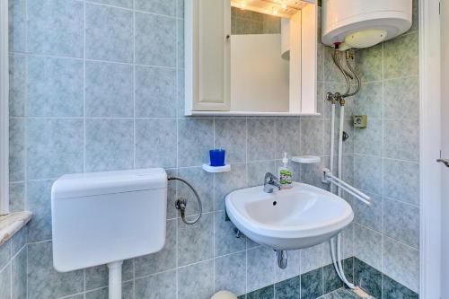 a bathroom with a sink and a mirror at Apartman Meri in Cres