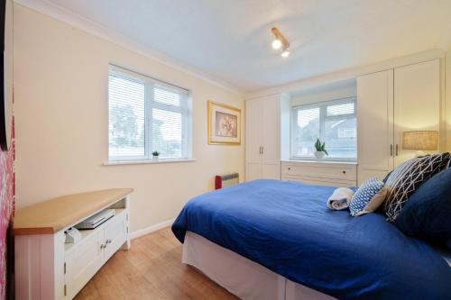 a bedroom with a blue bed and a desk at Private luxurious apartment in Easthampstead