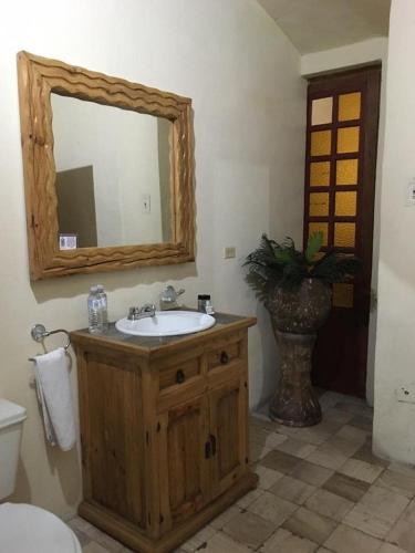 a bathroom with a sink and a mirror and a toilet at Hotel Boutique Casa de la Palma in Puebla
