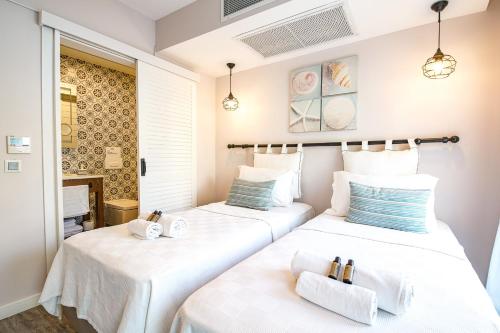 two beds in a room with white sheets at Nirvana Hotel in Bozcaada