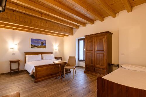 een slaapkamer met een bed en een bureau in een kamer bij il Glicine B&B RISTORANTE in Cazzago San Martino