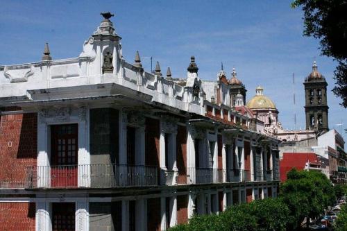 a building with a clock tower on top of it at Hotel Boutique Casa de la Palma in Puebla