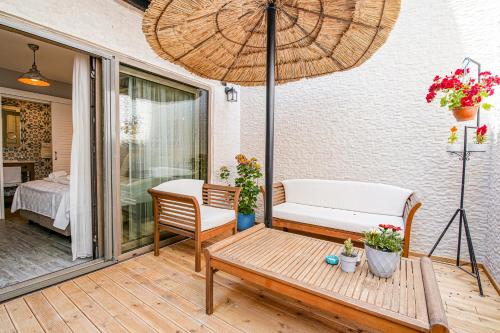 a patio with a bench and an umbrella at Nirvana Hotel in Bozcaada