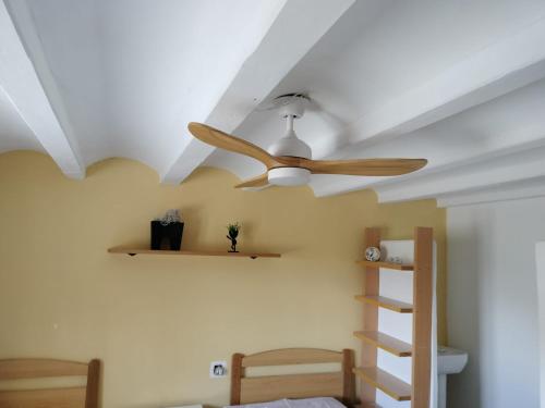 a ceiling fan and shelves in a bedroom at Masia Bernat in Tortosa