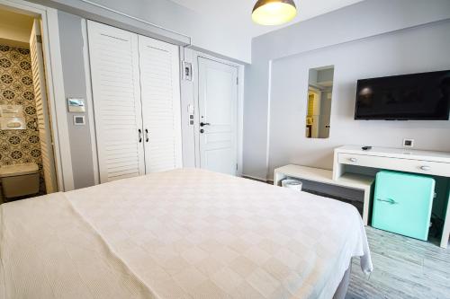 a bedroom with a bed and a flat screen tv at Nirvana Hotel in Bozcaada