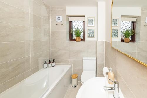 a bathroom with a tub and a toilet and a sink at Central Birmingham Luxury House, Sleeps 6 people - 10 mins from Solihull NEC, JLR, BHX Airport, Resorts World in Birmingham